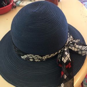 Blue straw hat with black, grey and red ribbon